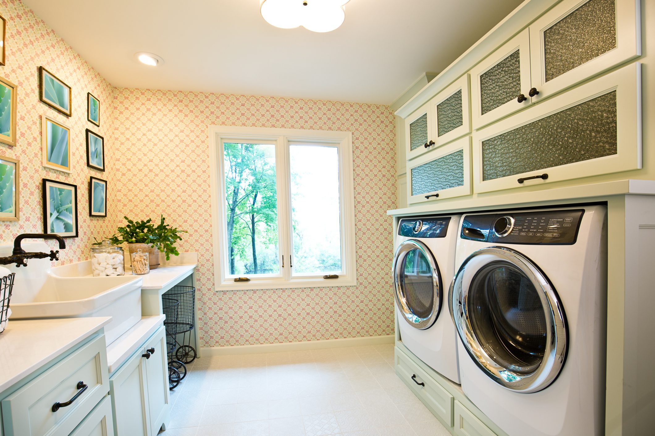 +++NOTE TO INSPECTOR+++ Framed photo on the wall are taken by me, and it is currently in iStock collection +++

Showcase interior design of a utility laundry room in a residential home in United States. with utility sink and fixture, washer and dryer, storage area.
